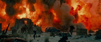 Movie still from “Transformers: Revenge of the Fallen” (2009), directed by Michael Bay – A man running in the desert near a car on fire; Extreme Wide shot, Over the shoulder angle