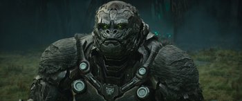 Movie still from “Transformers: Rise of the Beasts” (2023), directed by Steven Caple Jr. – A man's face in a costume; Close Up shot, Low angle