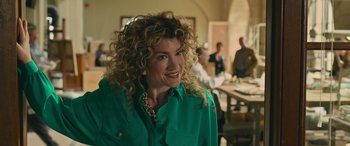 Movie still from “Transformers: Rise of the Beasts” (2023), directed by Steven Caple Jr. – A person with curly hair wearing a green shirt; Close Up shot, Over the shoulder angle