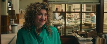 Movie still from “Transformers: Rise of the Beasts” (2023), directed by Steven Caple Jr. – A woman in a green shirt smiling for the camera; Close Up shot, Over the shoulder angle