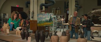 Movie still from “Transformers: Rise of the Beasts” (2023), directed by Steven Caple Jr. – A painting is being displayed in an art studio; Wide shot, Over the shoulder angle