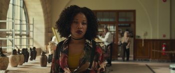 Movie still from “Transformers: Rise of the Beasts” (2023), directed by Steven Caple Jr. – A woman in a floral shirt and a yellow shirt; Close Up shot, Over the shoulder angle