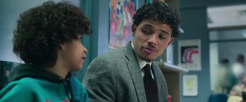 Movie still from “Transformers: Rise of the Beasts” (2023), directed by Steven Caple Jr. – A man in a suit and tie talking to a child; Close Up shot, Over the shoulder angle