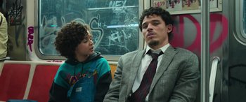 Movie still from “Transformers: Rise of the Beasts” (2023), directed by Steven Caple Jr. – A man and a boy are sitting on a train; Medium shot, Over the shoulder angle