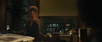 Movie still from “Transformers: Rise of the Beasts” (2023), directed by Steven Caple Jr. – A woman standing in front of a table with papers on it; Medium shot, Over the shoulder angle