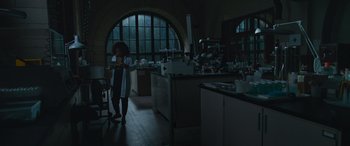 Movie still from “Transformers: Rise of the Beasts” (2023), directed by Steven Caple Jr. – A woman standing in front of a kitchen filled with pots and pans; Wide shot, Low angle