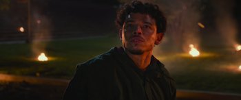 Movie still from “Transformers: Rise of the Beasts” (2023), directed by Steven Caple Jr. – A person wearing a hooded jacket; Close Up shot, Low angle