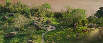 Movie still from “Transformers: Rise of the Beasts” (2023), directed by Steven Caple Jr. – An aerial view of a small village in the middle of the jungle; Extreme Wide shot, High angle
