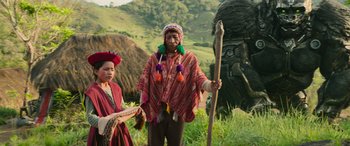 Movie still from “Transformers: Rise of the Beasts” (2023), directed by Steven Caple Jr. – A man and a woman standing in front of a statue; Wide shot, Low angle