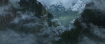 Movie still from “Transformers: Rise of the Beasts” (2023), directed by Steven Caple Jr. – A view of a mountain with a cloud filled sky above it; Extreme Wide shot, High angle