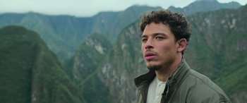 Movie still from “Transformers: Rise of the Beasts” (2023), directed by Steven Caple Jr. – A man standing on top of a mountain looking into the distance; Close Up shot, Low angle