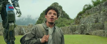 Movie still from “Transformers: Rise of the Beasts” (2023), directed by Steven Caple Jr. – A young man standing in front of a rock formation; Close Up shot, Low angle