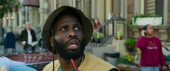 Movie still from “Transformers: Rise of the Beasts” (2023), directed by Steven Caple Jr. – A man with a beard is holding a stick in his mouth; Close Up shot, Low angle