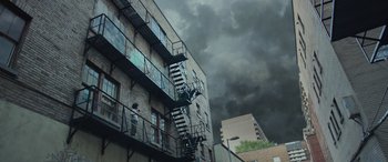 Movie still from “Transformers: Rise of the Beasts” (2023), directed by Steven Caple Jr. – A fire escape on the side of an apartment building; Extreme Wide shot, Low angle
