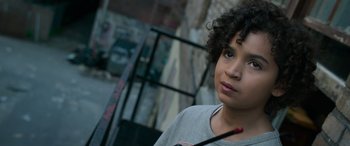 Movie still from “Transformers: Rise of the Beasts” (2023), directed by Steven Caple Jr. – A young boy is looking into the distance; Close Up shot, High angle