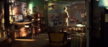 Movie still from “Transformers: The Last Knight” (2017), directed by Michael Bay – A man standing in front of a wall in a room; Wide shot, High angle