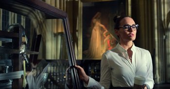 Movie still from “Transformers: The Last Knight” (2017), directed by Michael Bay – A woman in a white shirt is holding a cello; Medium shot, Low angle