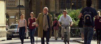 Movie still from “Transformers: The Last Knight” (2017), directed by Michael Bay – A group of people walking down a street; Wide shot, Low angle