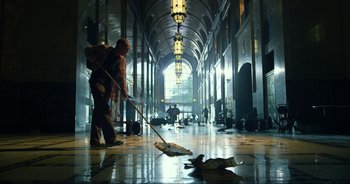 Movie still from “Transformers: The Last Knight” (2017), directed by Michael Bay – A person sweeping the floor in a large building; Extreme Wide shot, Low angle