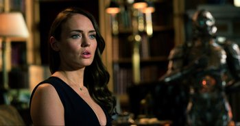 Movie still from “Transformers: The Last Knight” (2017), directed by Michael Bay – A beautiful woman standing in front of a bookshelf; Close Up shot, Over the shoulder angle