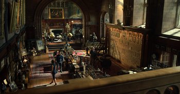 Movie still from “Transformers: The Last Knight” (2017), directed by Michael Bay – A group of people standing around in a room; Extreme Wide shot, High angle