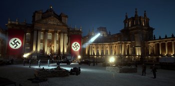 Movie still from “Transformers: The Last Knight” (2017), directed by Michael Bay – A large nazi flag hanging in the middle of a courtyard; Extreme Wide shot, Low angle