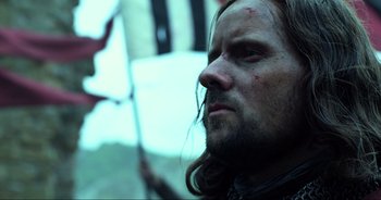 Movie still from “Transformers: The Last Knight” (2017), directed by Michael Bay – A person with long hair and a beard; Close Up shot, Low angle