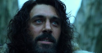 Movie still from “Transformers: The Last Knight” (2017), directed by Michael Bay – A man with long hair and a goatee stares into the distance; Close Up shot, Low angle