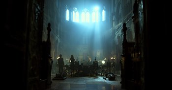 Movie still from “Transformers: The Last Knight” (2017), directed by Michael Bay – A group of people sitting around a table in a room; Extreme Wide shot, Low angle