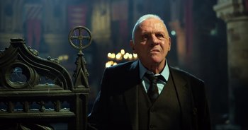 Movie still from “Transformers: The Last Knight” (2017), directed by Michael Bay – A person wearing a suit and tie; Close Up shot, Low angle