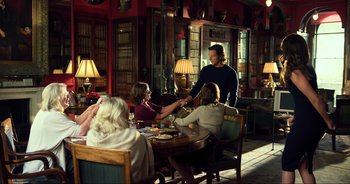 Movie still from “Transformers: The Last Knight” (2017), directed by Michael Bay – A group of people sitting around a table; Wide shot, Over the shoulder angle