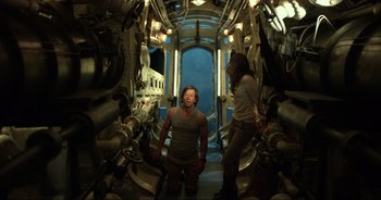 Movie still from “Transformers: The Last Knight” (2017), directed by Michael Bay – A man and a woman standing inside of a submarine; Medium shot, Over the shoulder angle