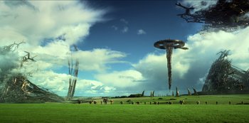 Movie still from “Transformers: The Last Knight” (2017), directed by Michael Bay – A group of people standing on top of a grass covered field; Extreme Wide shot, Low angle