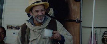 Movie still from “Troll” (2022), directed by Roar Uthaug – A man with a beard and a hat holding a cup of coffee; Medium shot, Over the shoulder angle