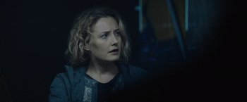 Movie still from “Troll” (2022), directed by Roar Uthaug – A woman with curly hair looking out a window at night; Close Up shot, Over the shoulder angle