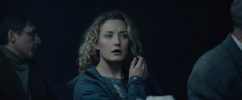 Movie still from “Troll” (2022), directed by Roar Uthaug – A woman with curly blonde hair looking at the camera; Close Up shot, Low angle