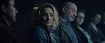Movie still from “Troll” (2022), directed by Roar Uthaug – A woman and a man sitting next to each other in a dark room; Close Up shot, Low angle