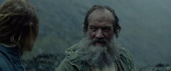 Movie still from “Troll” (2022), directed by Roar Uthaug – An old man with a long beard is looking at the camera; Close Up shot, Low angle