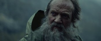 Movie still from “Troll” (2022), directed by Roar Uthaug – An old man with a long white beard and blue eyes; Close Up shot, Low angle
