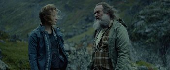 Movie still from “Troll” (2022), directed by Roar Uthaug – A man and a woman standing next to each other on a mountain; Medium shot, Low angle