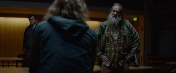Movie still from “Troll” (2022), directed by Roar Uthaug – An old man with a long white beard standing next to a woman; Medium shot, Over the shoulder angle