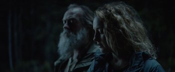 Movie still from “Troll” (2022), directed by Roar Uthaug – A man and a woman sitting next to each other in the dark; Close Up shot, Over the shoulder angle
