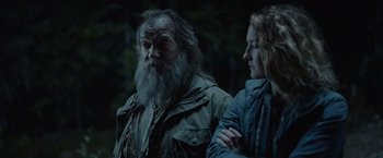 Movie still from “Troll” (2022), directed by Roar Uthaug – A man and a woman standing next to each other in the woods; Medium shot, Over the shoulder angle