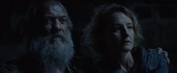 Movie still from “Troll” (2022), directed by Roar Uthaug – A man and a woman standing next to each other in the dark; Close Up shot, Low angle