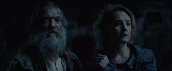 Movie still from “Troll” (2022), directed by Roar Uthaug – A man and a woman standing next to each other in the dark; Close Up shot, Low angle