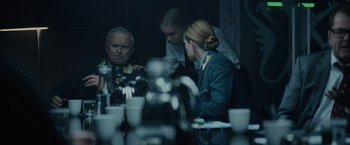 Movie still from “Troll” (2022), directed by Roar Uthaug – A group of people sitting around a table; Medium shot, Over the shoulder angle