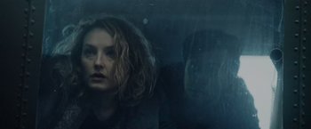 Movie still from “Troll” (2022), directed by Roar Uthaug – A woman with curly hair looking out of a window; Close Up shot, Low angle