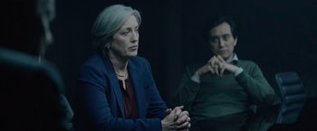 Movie still from “Troll” (2022), directed by Roar Uthaug – Two women sitting next to each other in a dark room; Medium shot, Over the shoulder angle