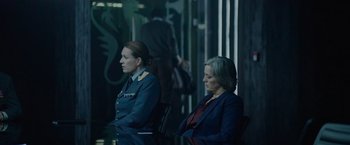 Movie still from “Troll” (2022), directed by Roar Uthaug – Two women sitting next to each other in a dark room; Medium shot, Over the shoulder angle