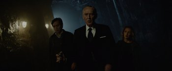 Movie still from “Troll” (2022), directed by Roar Uthaug – A man in a suit and tie standing next to another man in a suit and tie; Medium shot, Low angle